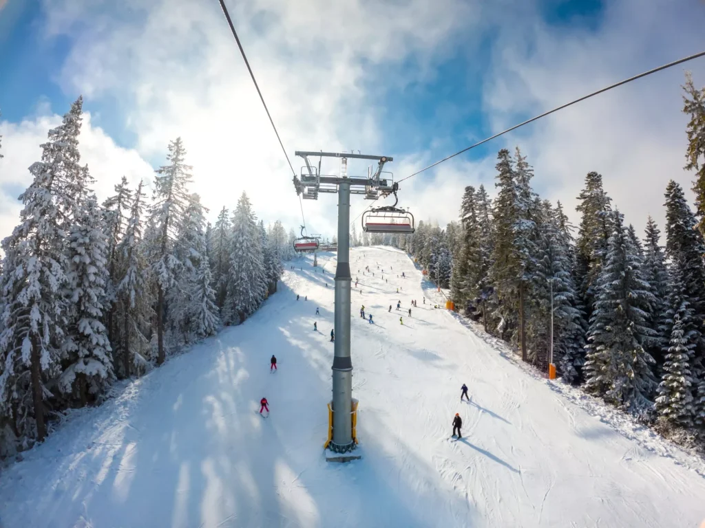 Schöne Berg Winterszene mit Sessellift und Skifahrer im Skigebiet. Winterurlaub Konzept