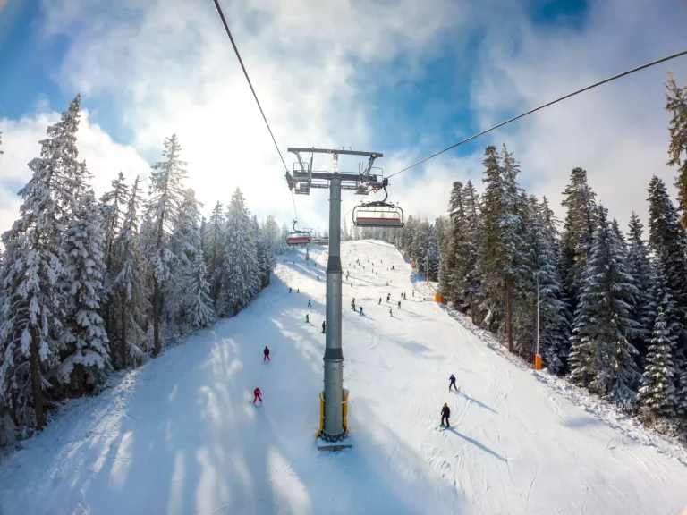 Beautiful mountain winter scene with chairlift and skiers at the ski resort. Winter vacation concept