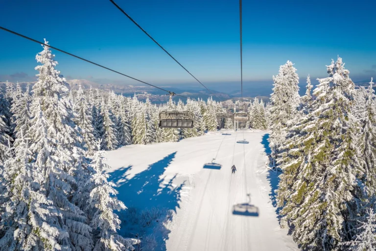 Ski lift with seats going over the mountain and ski tracks